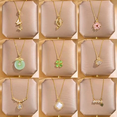 Nine gold pendant necklaces on beige display stands